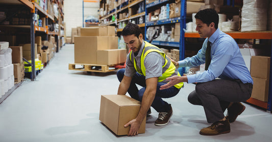 Worker receiving manual handling safety training from a manager