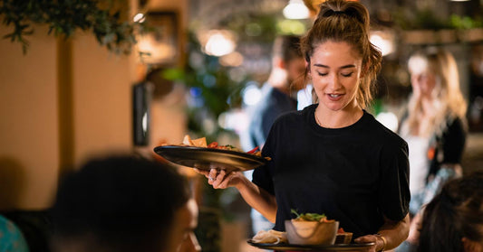 Waitress holding a tray and serving customers food at a restaurant