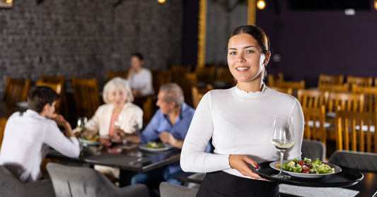 Server at a restaurant standing with serving tray