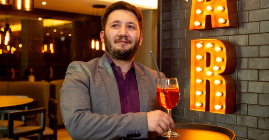 Barkeeper carrying cocktail on tray and looking out for potential trip hazards