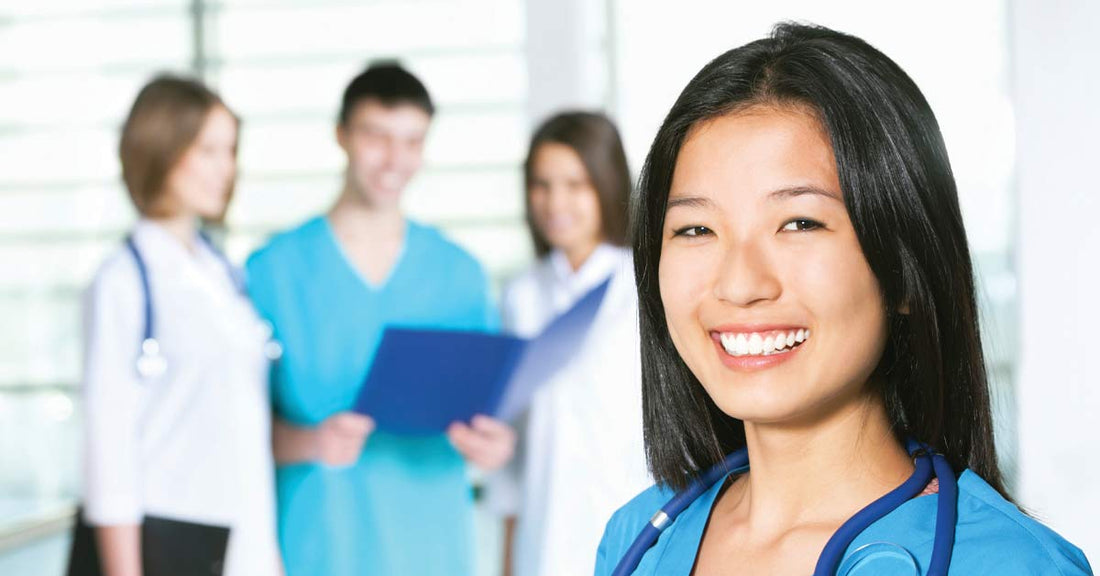 Nurse in uniform smiling with other nurses in faded out background