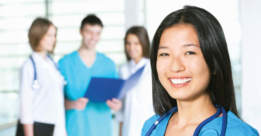 Nurse in uniform smiling with other nurses in faded out background