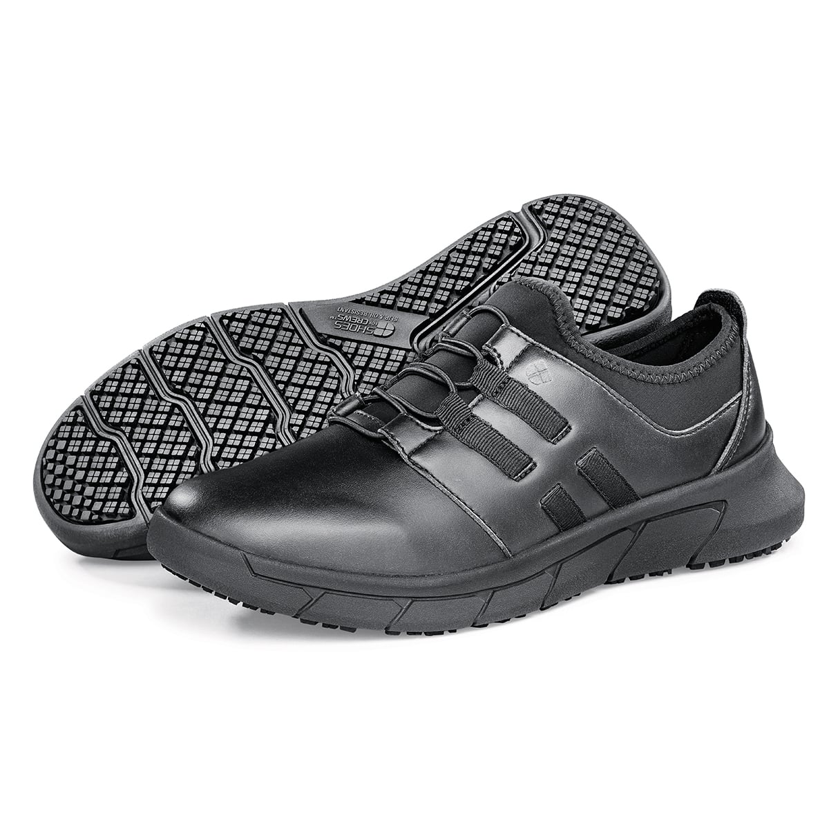 The Karina Black by Lila from Shoes For Crews are black slip-resistant trainers that are lightweight and have Flex Tread technology, pair seen from the left side and the sole.