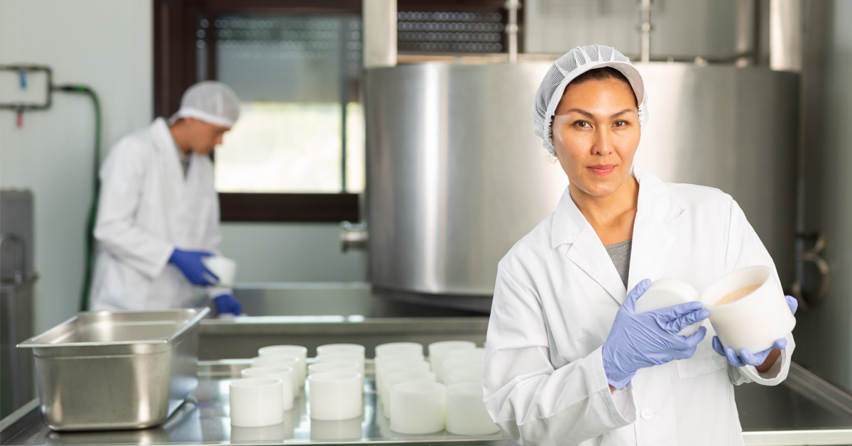 Femme en blouse blanche travaillant dans une usine alimentaire