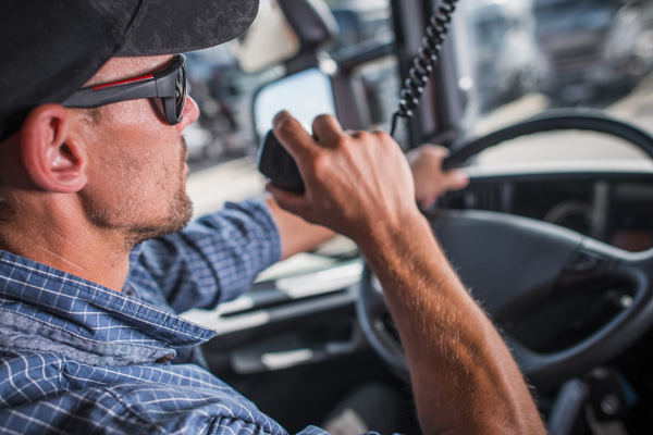 HGV driver using lorry radio to communicate with other drivers and management